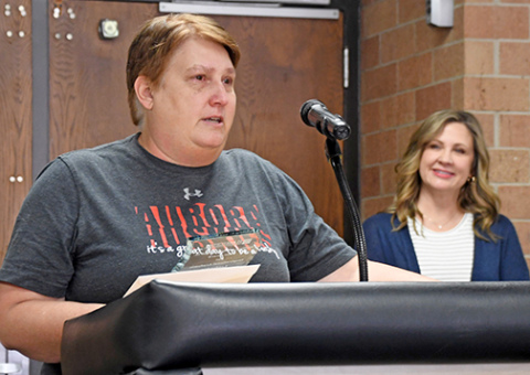 Aurora High School teacher Brenda Klawonn speaks to school staff on Friday afternoon after being presented with the 2024 William C. and Delight M. Eloe Award by Tammy Morris of the Hamilton Community Foundation (right).