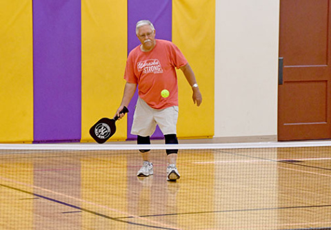 Warming up for a Wednesday evening game, Hampton resident Craig Dallegge takes a swing at the pickleball.