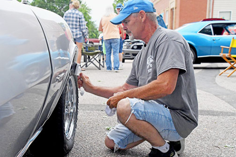 Gary Holling from Superior washes off the wheel of his silver 1968 Chevy Camaro at the Giltner Daze Car Show on Saturday.