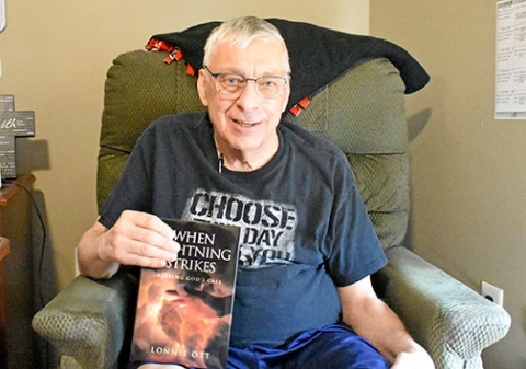 Lonnie Ott sits in his room at Westfield Quality Care holding a copy of his book: “When Lightning Strikes: Hearing God’s Call.” Ott says it took him 10 years to write the book. 