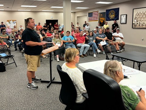 Randy Beckman speaks to the Marquette Village Board during Monday’s public hearing regarding a controversial sign issue.