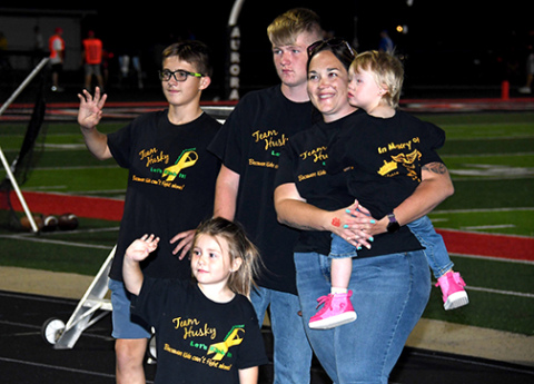 Melissa Widner holds her daughter, Bailey, during Friday’s half-time PCAN presentation. Bailey is now in remission, a year after the family received proceeds from the Aurora PCAN donation night in the midst of her battle against cancer.