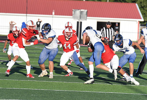 The sun shone brightly as the game began on a picture-perfect night for the season opener, a contest the Huskies dropped to Pierce, 41-28. Aurora defenders move in here to stop Brenden Bolling for no gain.