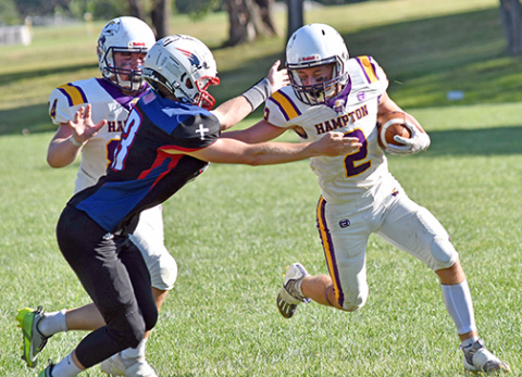 Hampton back Jack Bullis throws a mean stiff arm on his way to a rushing touchdown, one of four on the day and eight TDs in the game. 