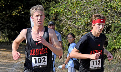 Charlie Evans (left) and Jayden Slagle race side by side throughout the Crete course at Doane University. Evans ran second in the boys race with Slagle placing fourth. 