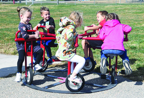 One of the many examples of students benefitting from funding provided through the Aurora Public Schools Foundation is this Merry-go-cycle, which has become a favorite for Aurora preschoolers. Pictured giving it a whirl are, from left: Loralai Farrand, Merrick Reiker, Avery McCartney, Owen Lewis and Benjamin Gomez. The equipment was actually purchased by HCF’s Women in Philanthropy as part of a growing partnership between the two foundations.
