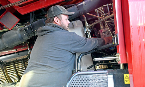 Josh Roehrs, a 2013 Hampton graduate, is a mechanic at Grosshans International while still getting his hands dirty on the farm. 