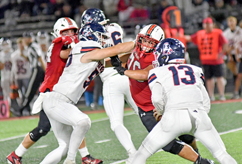 Aurora’s Jeryn McClain (76) beats his man and puts pressure on AC’s QB Jackson Sughroue late in the second half of the Huskies’ 21-7 win over the Patriots Friday. 