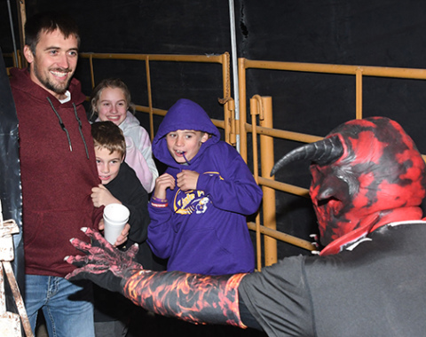 Jared Rojewski, left, and some young friends are confronted by a devilish character (George Chaney) at the 2022 apparition of Haunted Fairgrounds. This year’s Hamilton County Ag Society haunting begins this Friday and goes through Sunday and will continue next weekend, Oct. 25-27, as well.  