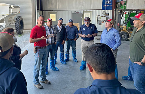 Hamilton County corn grower Nate Goertzen (left) talks with members of a Mexican trade mission group that visited his farm in October. The members of the team are wearing boot covers to avoid the risk of transporting contaminants from one country to another. 
