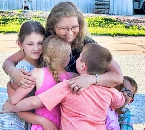 Sharon Goertzen gets a group hug from some of the last children she took care of in her home before her retirement from childcare in May. This photo was snapped by a parent after her retirement party when this group of children spontaneously ran to Goertzen to give her one more hug. 