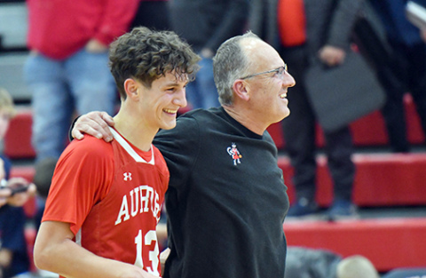 Aurora senior Parker Smith (left) and coach Kevin Asher celebrate in the moments after Aurora’s 49-43 win at Adams Central Thursday, the 500th career win for the longtime mentor. Smith buried a pair of game-defining three-point shots in the fourth quarter. 