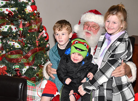 Pictured with Santa are, from left, cousins Damon Journey, Kane Madden and Emma Journey.