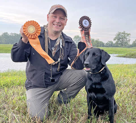 Zach Tesar and his dog, Sioux, pose for a photo after earning Senior hunting retrieving titles last summer. 