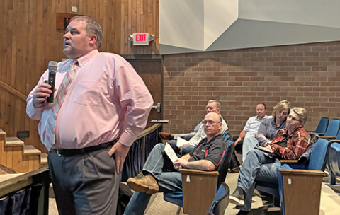 Aurora Supt. Jody Phillips looks toward a large projection screen in the middle school theater while making a presentation about the district’s proposal to expand the preschool program. Looking on in the background are members of the Aurora School Board.