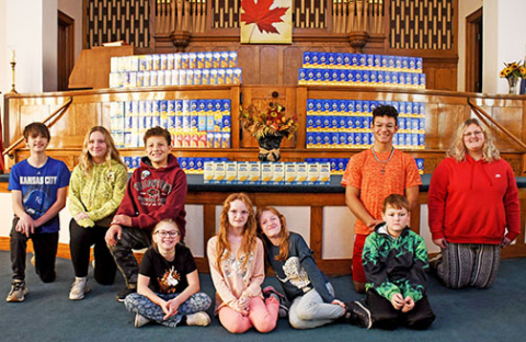 Members of the combined Aurora First Christian Church/Presbyterian UCC Youth Group pose in front of the more than 200 boxes of macaroni and cheese they collected through their recent Mac & Cheese Challenge. Seated in front, from left, are Allyson Schmidt, Myra Williams, Megan Williams, Kale Williams; back row, Kyler White, Annabelle Manley, Marcus Skarniak, Chris Skarniak and Khloe Williams. 