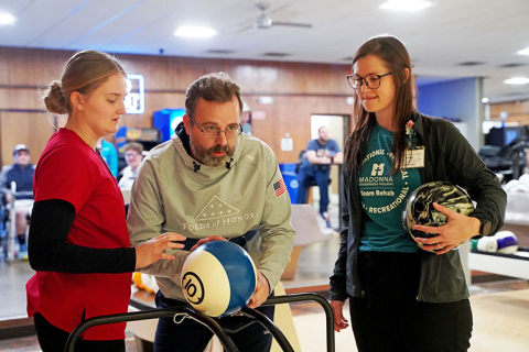 Therapists at Madonna Rehabilitation Hospital in Lincoln use a bowling ball to help Ryan Goertzen recover the use of his right arm.