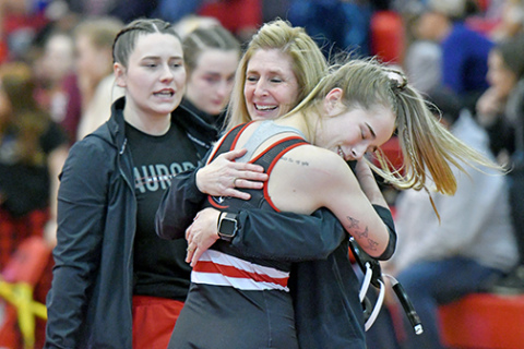Aurora’s Caly Settles celebrates with coach Sheri Thompson after surviving the heartbreak round to officially qualify for the state wrestling championships in Omaha. 