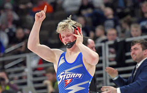Gage Friesen let some rare emotion come out after his state championship victory while coaches Martin Phillips (right) and Corbey Grause celebrate in the background. 