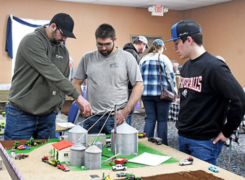 The Leadership Center hosted its first Farm Toy Show on Sunday with visitors and vendors coming from all over Nebraska eager to find antique farm toys in addition to dolls, games and other pop culture items offered at the show. Event co-organizer Chaz Boeder (right) showcases his farm toy model to brothers Jake and Garrett Byerly.