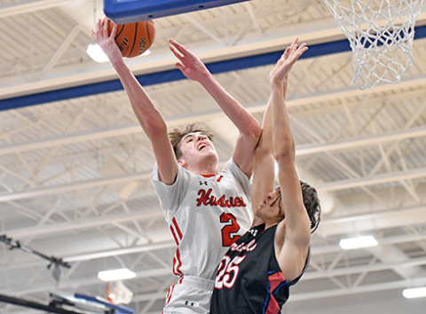 Booker Scheierman finishes with contact at the rim during Aurora’s 57-48 win over Crete in Saturday’s Central Conference final.  