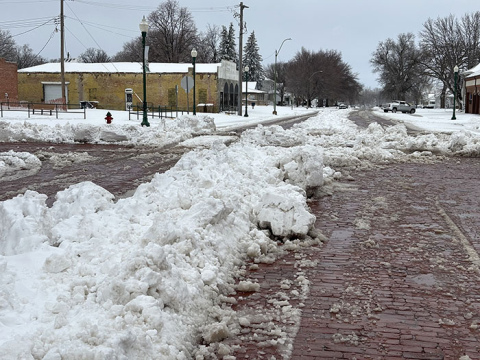 City crews have begun clearing streets in Aurora, though piles of wet, heavy snow remain in the center of some streets, making travel difficult.