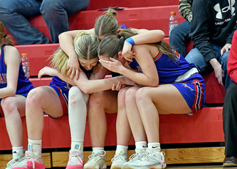 HPC seniors Emma Brown (far left), Courtney Carlstrom (middle) and Rylee Ackerson comfort one another after the D1-4 district final game against Superior. 