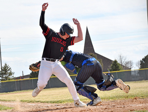 Jack Spiehs dances around a tag at the plate to score an early run for the Huskies. 