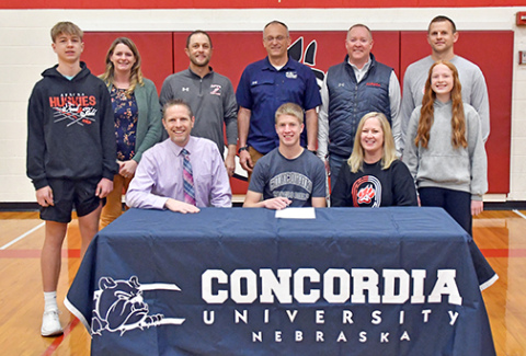 Aurora senior Charlie Evans signed with Concordia University to run both cross country and track and field for the Bulldogs. Joining Evans includes, front row from left: William Evans, Christian Evans, Susie Evans, Lauren Evans. Back row: Faith Gustafson, Aurora XC coach Tony Sigler, Concordia coach Matt Biesel, Aurora track coach Gordon Wilson, Aurora track coach Cole Carraher. 