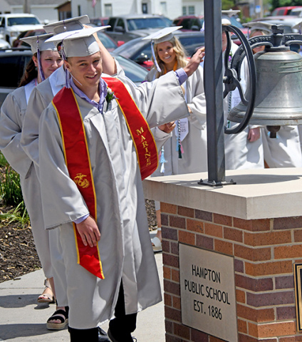 Jackson Bullis takes his turn at ringing the old school bell as the Hampton High School Class of 2025 heads into the school for Saturday’s graduation. 