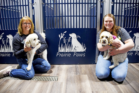 Prairie Paws is a family-owned dog grooming business west of Marquette run by mother Amy (left) and daughter Logan Nissen. The business also provides cremation services for families. Posing alongside Logan and Amy are Tucker and Tellula. 