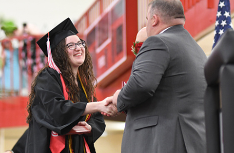 Aurora senior Jorja Pohlmeier, who was one of two class speakers on Sunday, is congratulated by Supt. Jody Phillips after receiving her diploma.