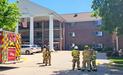 Firefighters and residents wait outside East Park Villa on Tuesday afternoon while fire officials inside the building seek out the source of an alarm that had sounded, prompting an evacuation of residents and staff. 