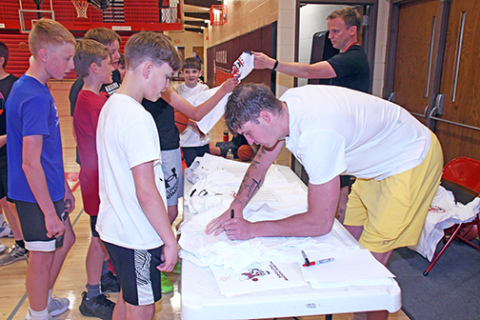 Baylor Scheierman signs autographs for boys participating in the Husky Hoops Factory summer camp earlier this month in the very same gym where he started his basketball career. Camp t-shirts were handed out and Scheierman signed both the t-shirts and the boys’ athletic shoes. 
