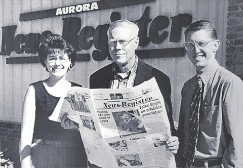 In 2000, Butch Furse, center, announced the sale of the Aurora News-Register to Kurt and Paula Johnson. 