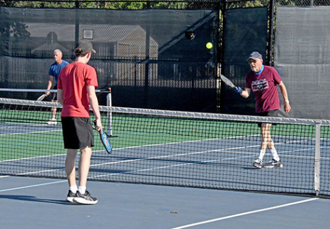 Dr. John Wilcox (right) and his grandson, Shawn Morris, both of Aurora, warm up before the start of the multi-generational pickleball tournament on Friday evening. 