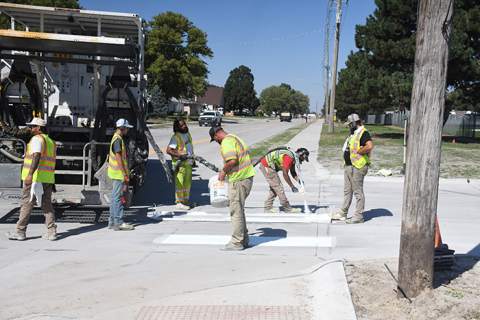 Crews were busy painting lines on the new portion of 1st Street near the school Thursday afternoon.