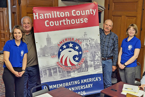 The Hamilton County Board of Commissioners was presented with an America 250 banner to be put on display in the county courthouse in preparation for the nation’s 250th birthday celebration in 2026. The presentation was made by members of the Hamilton County Nebraska Celebrate 250 Committee. Pictured from left are Jennifer Dennis, Commission Chairman Rich Nelson, Commissioner Francis McDonald and Kathryn Larson. 