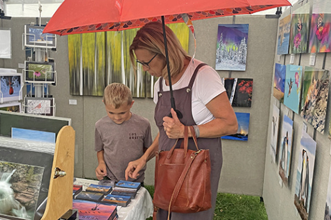 Lee Olsen and his grandmother Betty browse through several photos taken by Rick Rasmussen of Platter River Photography during Sunday’s Art Walk Aurora.
