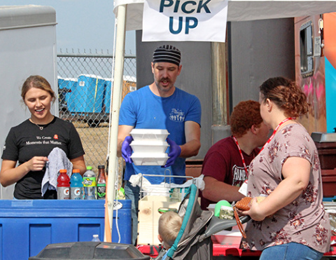 The Leadership Center Executive Chef John Boeder, center, works the serving line at TLC's prime rib sandwich booth at Husker Harvest Days.