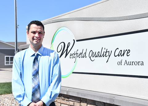 New administrator Chad Thompson stands by the sign in front of the Westfield Quality Care facility. 