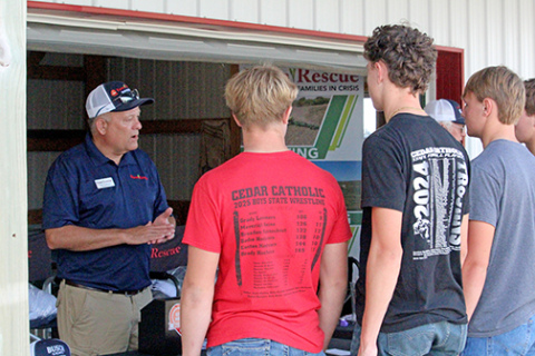 Tim Sullivan (left), executive director of Farm Rescue, visits with FFA students from Hartington at the organization’s booth at Husker Harvest Days. The non-profit, based in Jamestown, N.D., has hundreds of volunteers across 10 states ready to help farmers during a time of crisis with planting or harvest. 