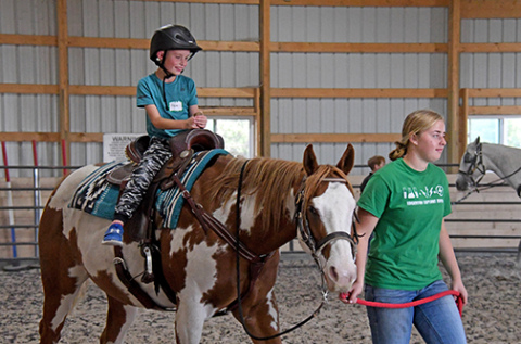 Rowan Bilslend enjoys his first ride as Arley McEndarfer guides horse Harley during the afterschool program’s horseback riding session on Wednesday, Oct. 1. 