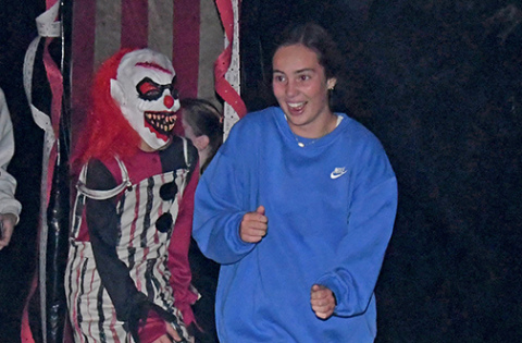 Avery Miller makes a quick escape from the Wolff Building as a clown (Brenden Zucco) chases after her Sunday night. Over 480 people visited the Hamilton County Haunted Fairgrounds during the opening weekend with many braving the maze twice or three times.