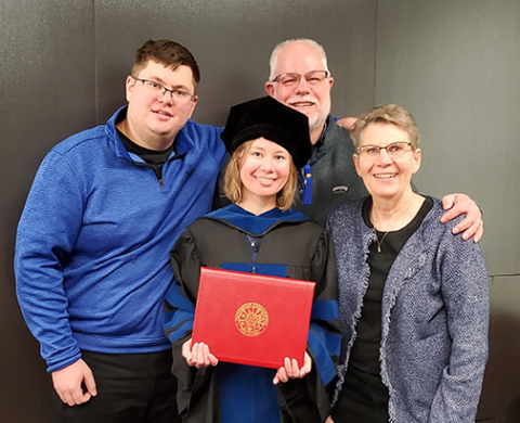 Katie Muilenburg (center) is a postdoctoral fellow at the National Cancer Institute Center for Cancer Research in Bethesda, focusing on liver cancer research. Pictured with Muilenburg from left are her brother Nathan, father Jeff and mother Cyndi.