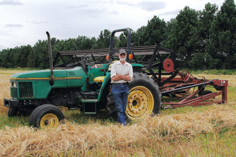 Mike Herman served as farm manager at Grain Place Foods near Marquette for more than 30 years, beginning in 1985. He is pictured here in 2015 with a photo that was appropriately labeled: “Outstanding in his field.”