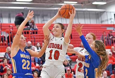 Kenna Merrihew pulls down an offensive rebound in heavy traffic during Aurora’s 43-35 loss to Wahoo Saturday. 