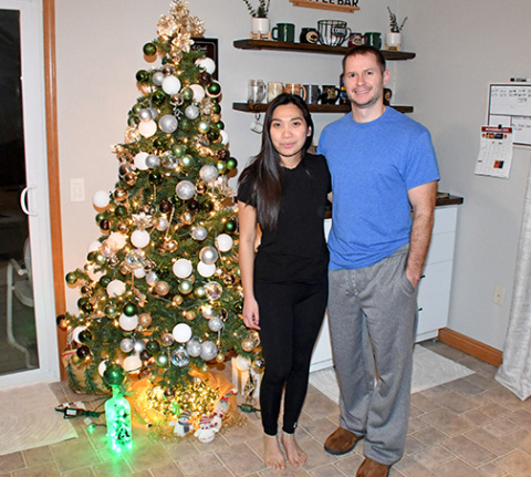 Newlyweds Kimmy and Eric Oberle stand next to the Christmas tree in their Aurora home. Since it was put up by Kimmy the first of September and won’t come down until near the end of January, it will have been up nearly half the year. 