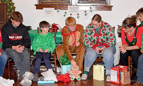 Exchange students open white elephant gifts at their Christmas party on Dec. 7