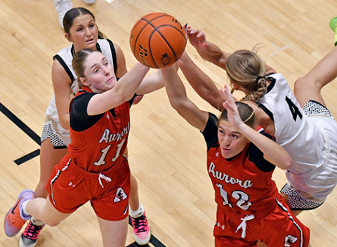 Aurora’s Kaitlyn Staehr (11) and Maddie Ramaekers (12) battle for an offensive rebound between two Northwest defenders during the Huskies’ 52-48 win over the Vikings Saturday, improving its record to 4-2 on the season. 